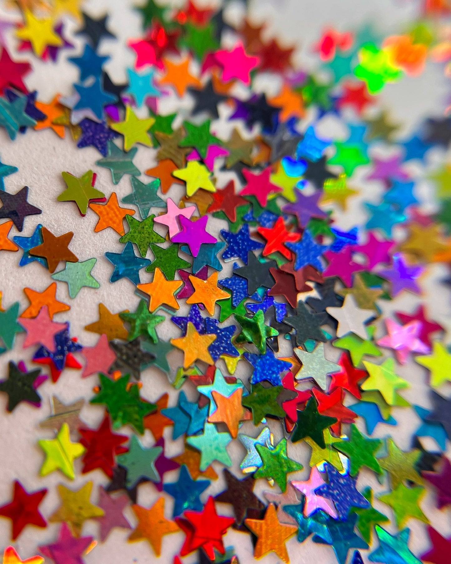 Multicolor star shape glitter scattered  on white background. 
