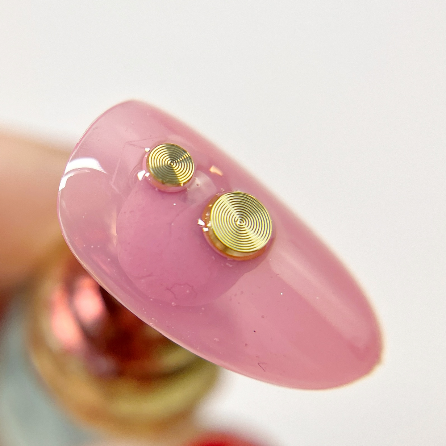 Hand holding decorated nail tip.