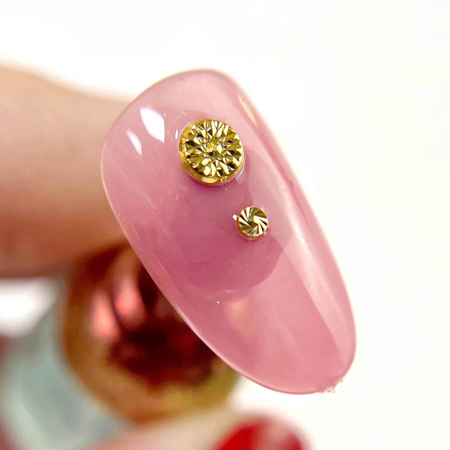 Hand holding decorated nail tip.