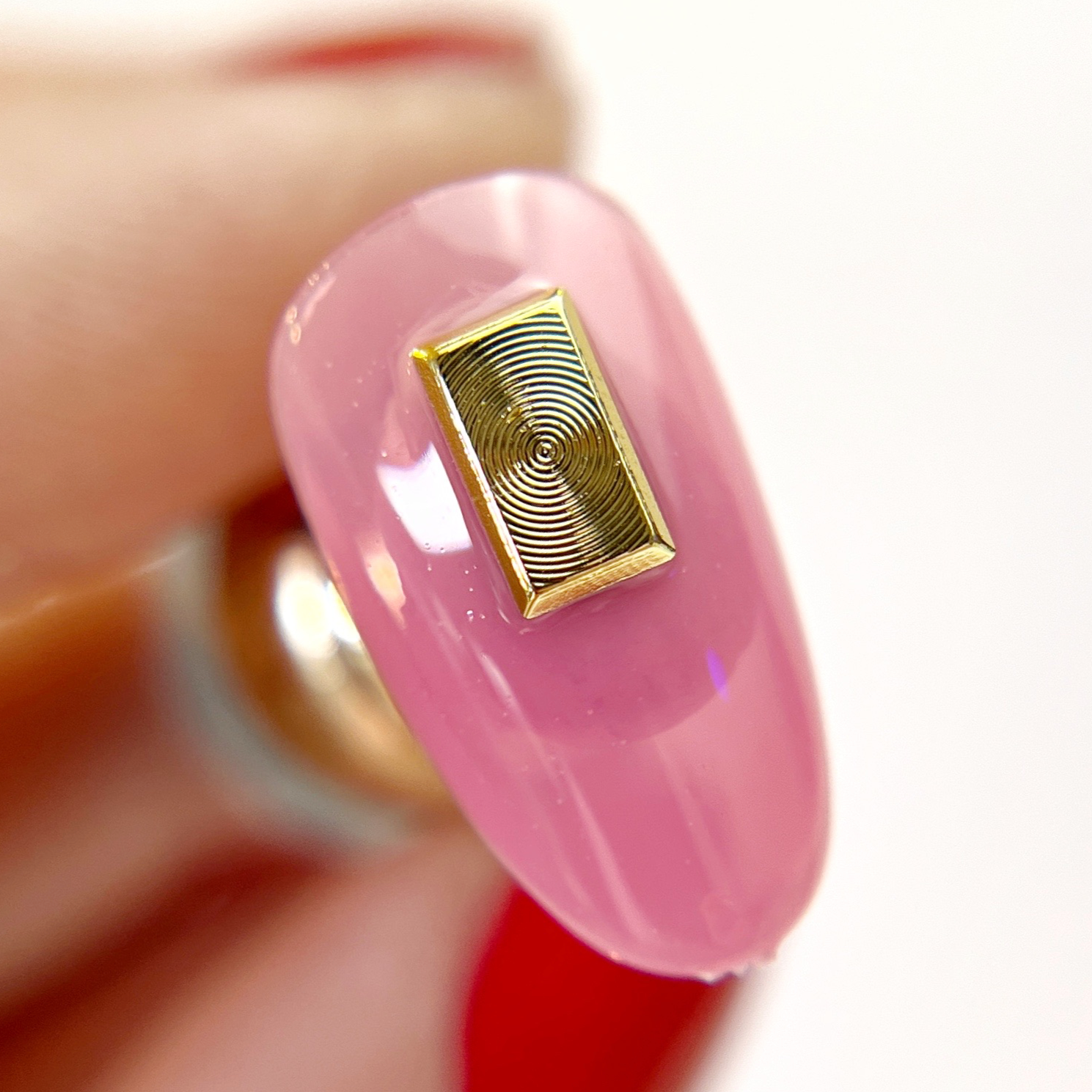 Hand holding decorated nail tip.