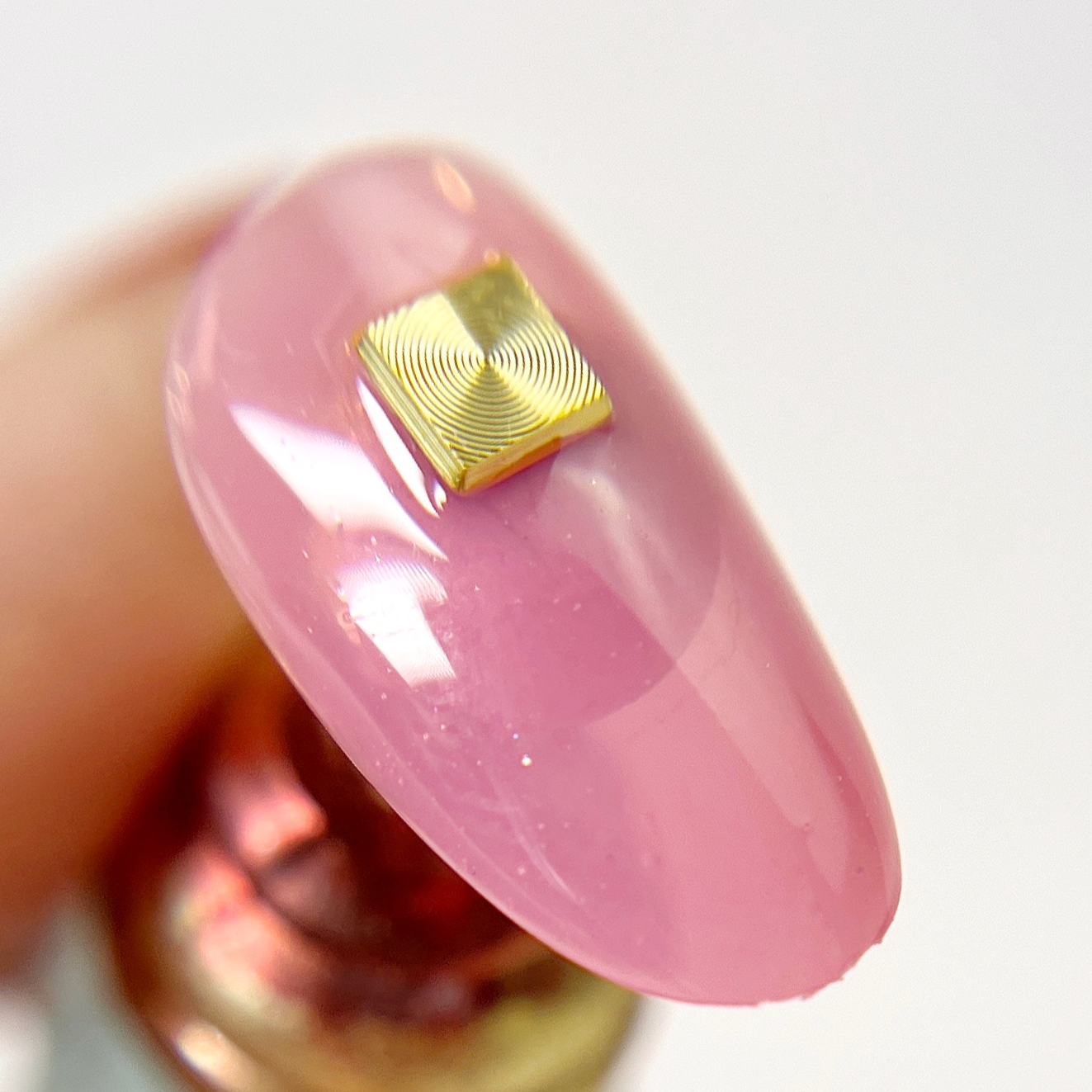 Hand holding decorated nail tip.